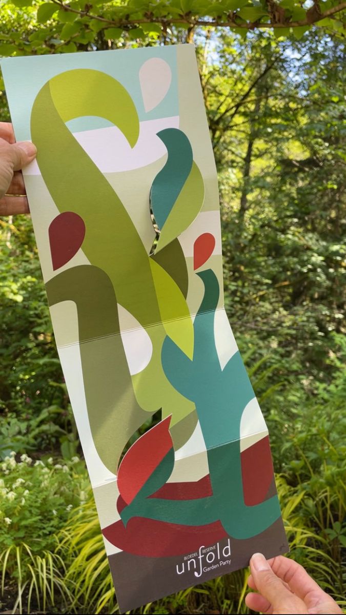 Invitation with bold artwork opened to a tall vertical format